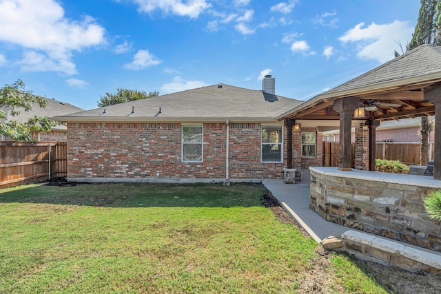 back of property featuring ceiling fan, a yard, and a patio area