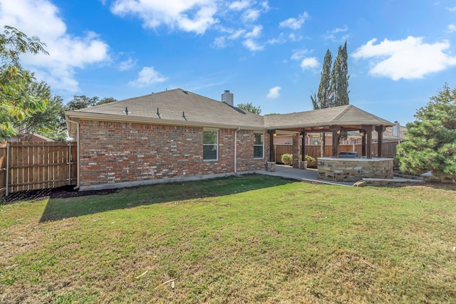 rear view of property featuring a hot tub, a lawn, a patio, and a gazebo