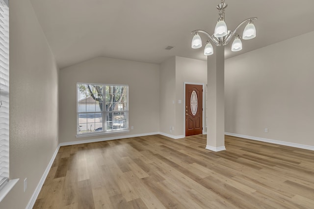 interior space featuring light hardwood / wood-style floors, vaulted ceiling, and an inviting chandelier