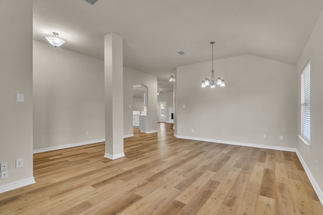 unfurnished living room with vaulted ceiling, a notable chandelier, and light hardwood / wood-style flooring