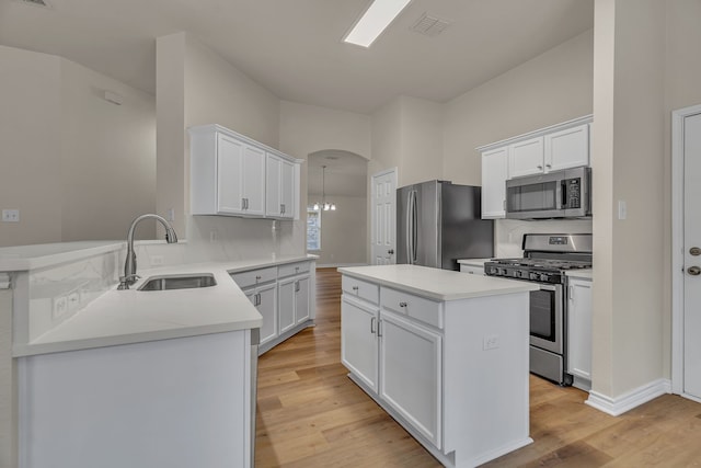 kitchen featuring light hardwood / wood-style floors, stainless steel appliances, a center island, sink, and white cabinetry