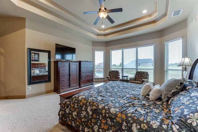 bedroom with ornamental molding, a tray ceiling, light carpet, and ceiling fan