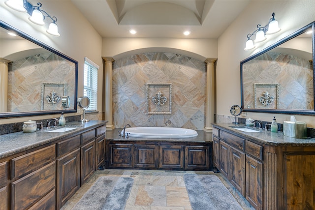 bathroom featuring a tub to relax in, vanity, and ornate columns