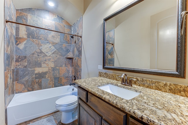 full bathroom with tiled shower / bath, toilet, vanity, and lofted ceiling