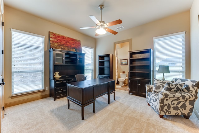 carpeted office space featuring ceiling fan