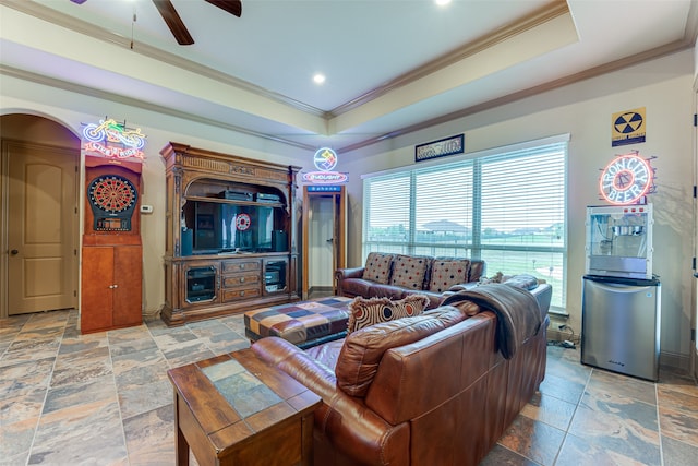 living room featuring ceiling fan, crown molding, and a tray ceiling