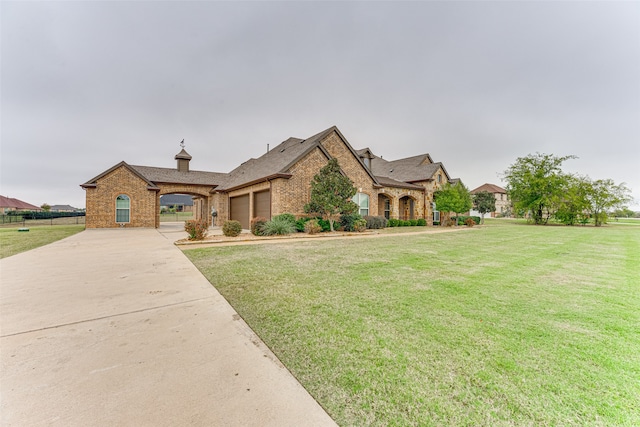 french country inspired facade featuring a garage and a front lawn