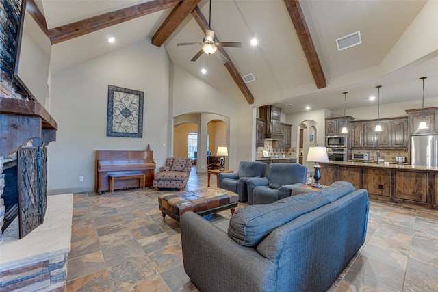 living room with high vaulted ceiling, ceiling fan, and beam ceiling