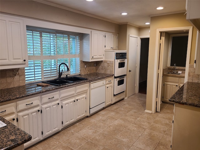 kitchen with white appliances, sink, and white cabinets