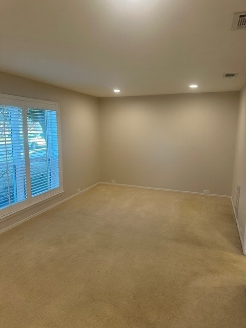 spare room with visible vents, a ceiling fan, vaulted ceiling, and dark wood finished floors