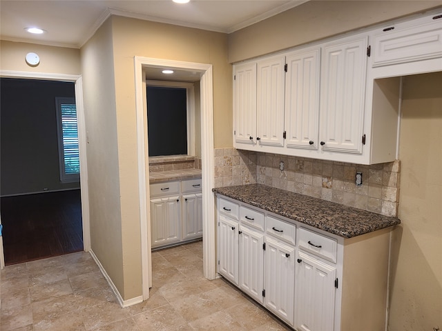 kitchen featuring white cabinets, ornamental molding, and backsplash