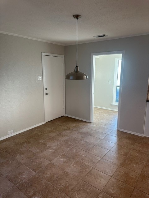 interior space with baseboards, a textured ceiling, visible vents, and crown molding