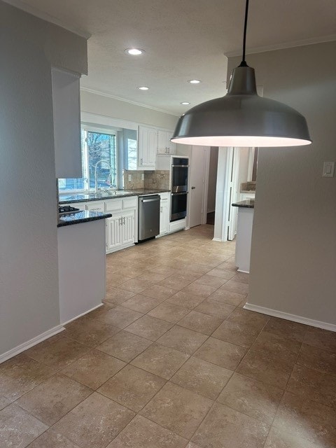 kitchen featuring stainless steel appliances, white cabinets, hanging light fixtures, and crown molding