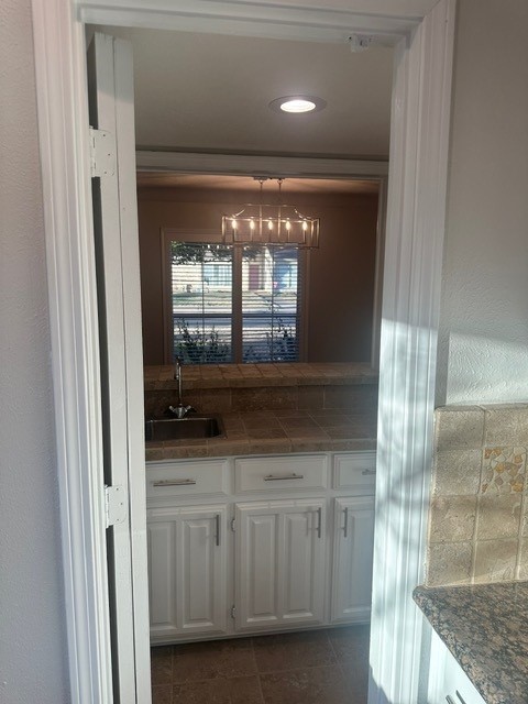 bar featuring dark tile patterned floors and a sink