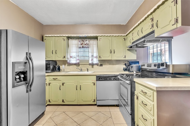 kitchen with appliances with stainless steel finishes, sink, light tile patterned flooring, and a textured ceiling