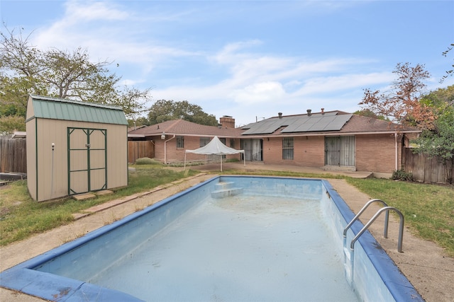 view of swimming pool featuring a shed and a yard