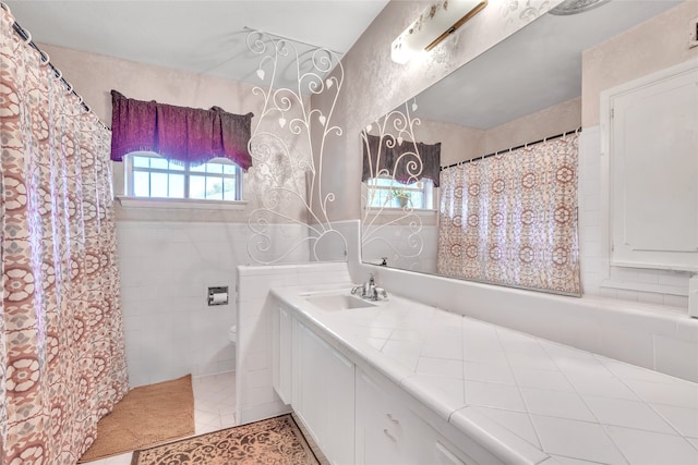 bathroom with walk in shower, vanity, and tile patterned floors