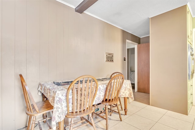 tiled dining space featuring wood walls, beam ceiling, and ornamental molding