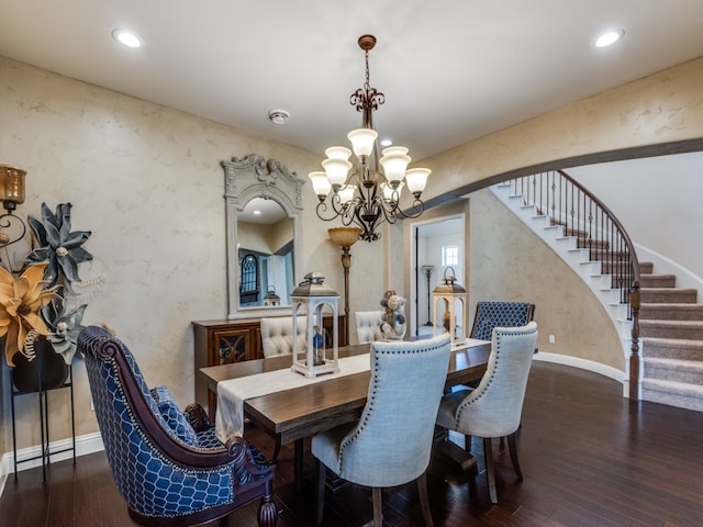 dining area featuring dark hardwood / wood-style flooring and an inviting chandelier