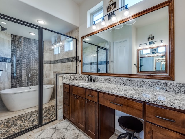 bathroom with tile walls, tile patterned flooring, vanity, and separate shower and tub