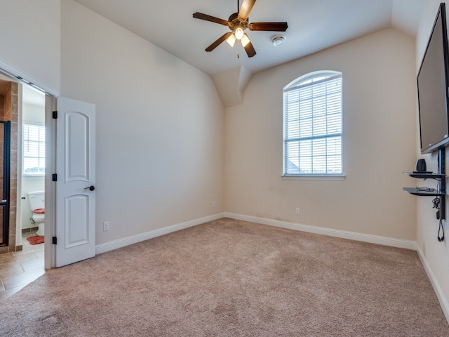 carpeted empty room with plenty of natural light, lofted ceiling, and ceiling fan