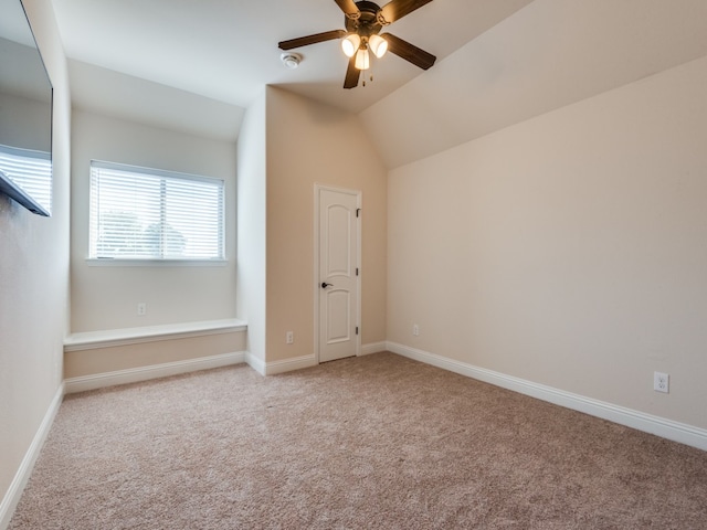 interior space with light colored carpet, ceiling fan, and vaulted ceiling