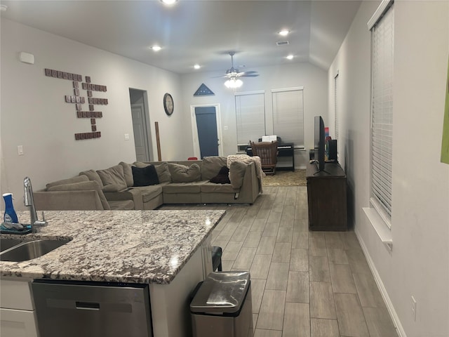 living room with ceiling fan, sink, light wood-type flooring, and vaulted ceiling