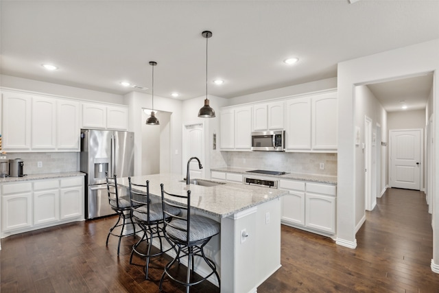 kitchen with backsplash, sink, a kitchen island with sink, and appliances with stainless steel finishes