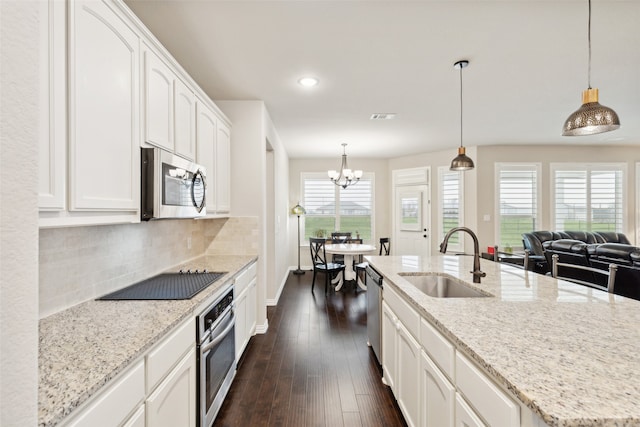 kitchen featuring stainless steel appliances, pendant lighting, sink, white cabinets, and dark wood-type flooring