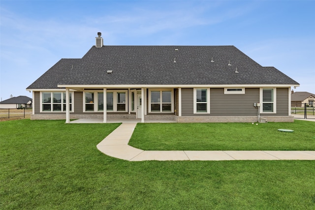 rear view of house featuring a lawn and a patio area