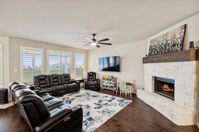 living room featuring a fireplace, dark wood-type flooring, and ceiling fan