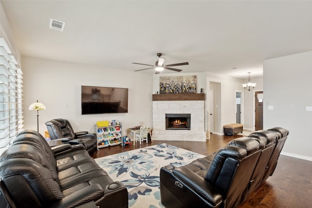 living room with a fireplace, ceiling fan with notable chandelier, and dark hardwood / wood-style flooring