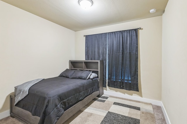 bedroom with a textured ceiling and light carpet