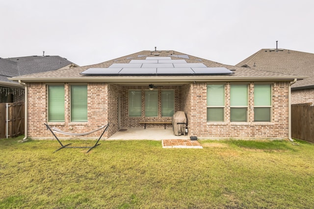 back of house featuring solar panels, a yard, and a patio area