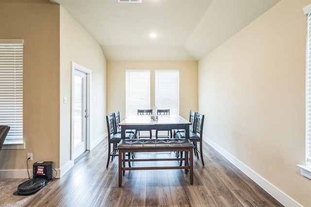 dining room with dark hardwood / wood-style flooring and lofted ceiling