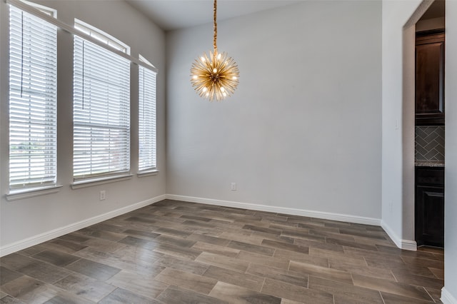 unfurnished dining area featuring a chandelier