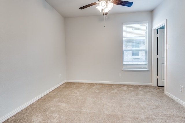 spare room with ceiling fan and light carpet