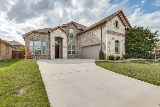 french country home with a front yard and a garage