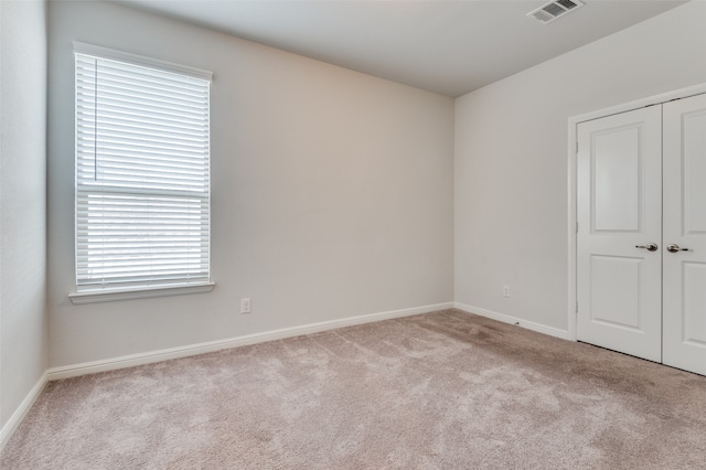 unfurnished room featuring light carpet