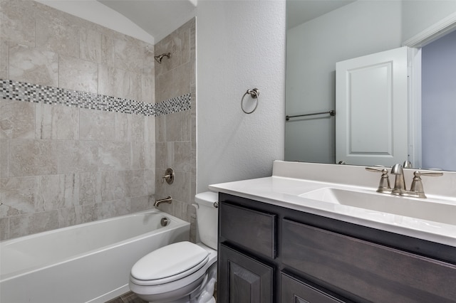 full bathroom featuring vanity, toilet, tiled shower / bath, and vaulted ceiling