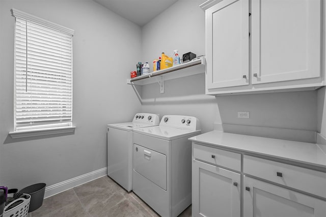 laundry room featuring cabinets, light tile patterned flooring, and independent washer and dryer