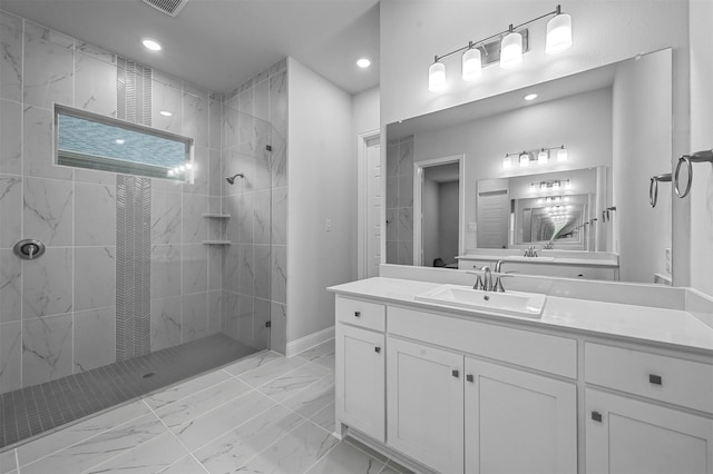 bathroom with vanity and tiled shower