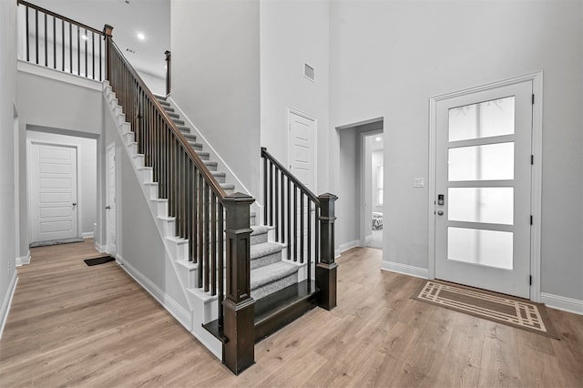 foyer with light hardwood / wood-style floors and a high ceiling