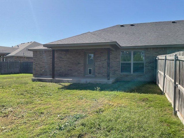 rear view of property featuring a yard