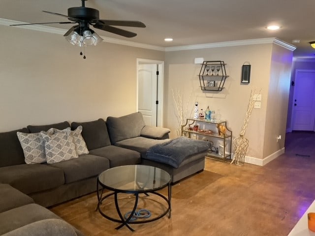 carpeted living room featuring ceiling fan and ornamental molding