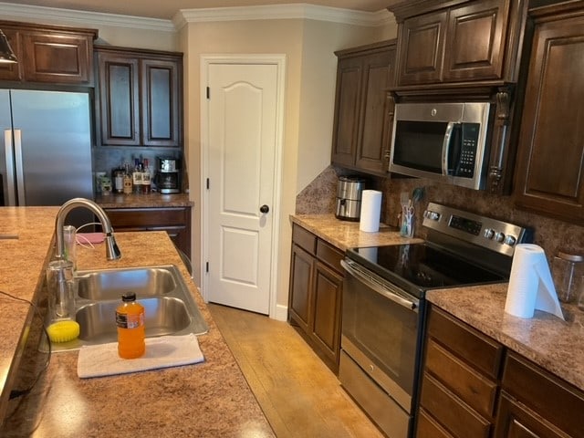 kitchen featuring light hardwood / wood-style floors, stainless steel appliances, sink, and tasteful backsplash