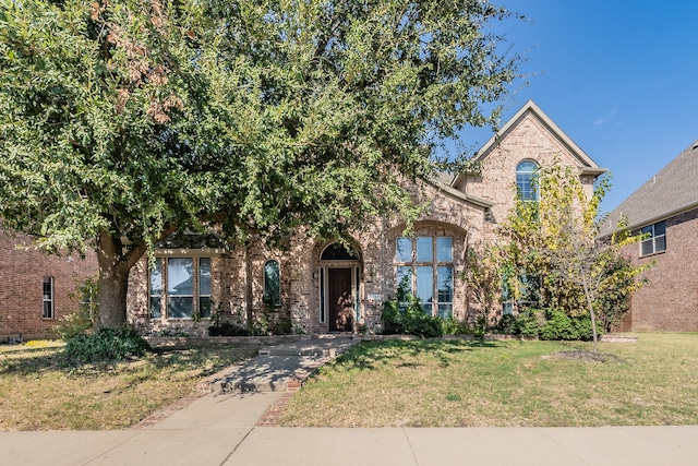 view of property hidden behind natural elements featuring a front lawn