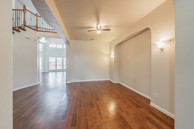 unfurnished living room featuring ceiling fan and dark hardwood / wood-style floors