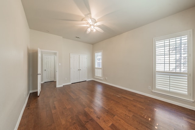 unfurnished bedroom featuring dark wood-type flooring and ceiling fan