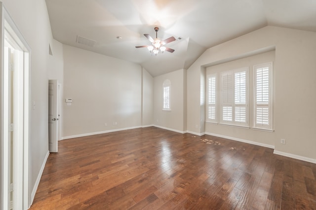 unfurnished room with vaulted ceiling, ceiling fan, a healthy amount of sunlight, and dark hardwood / wood-style flooring